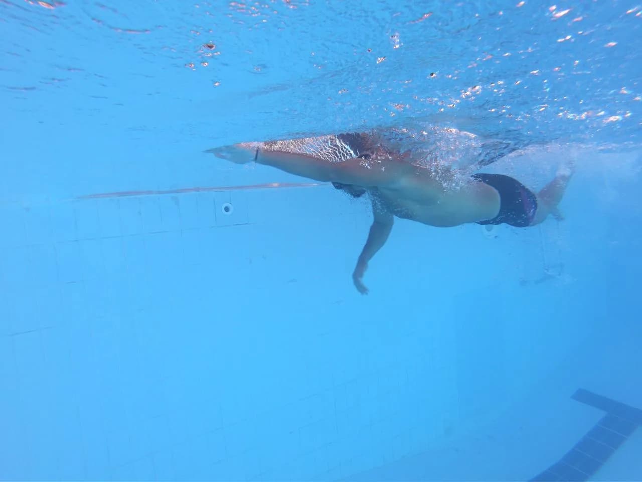 Swimmer practising stroke technique beneath the surface of a pool